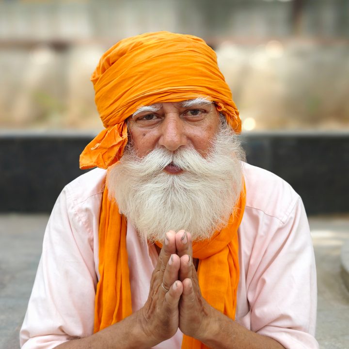 Portrait of an old man with folded hands sitting on a sidewalk in New Delhi, India clicked using Vivo X Fold 3 Pro with Zeiss cameras.