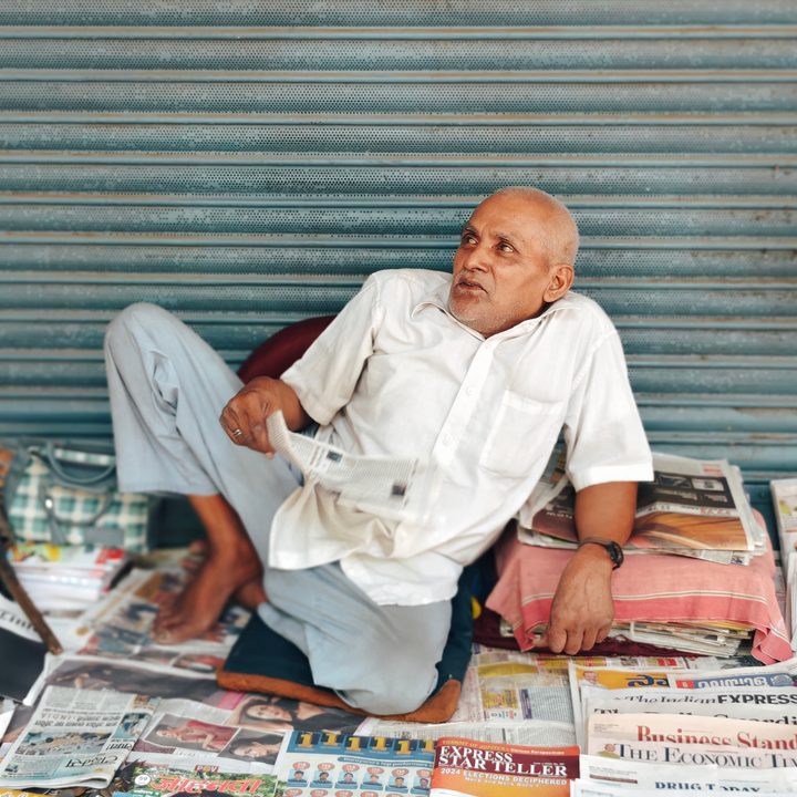 Newspaper and magazine seller in his shop on the sidewalk in New Delhi, India clicked using Vivo X Fold 3 Pro with Zeiss cameras.