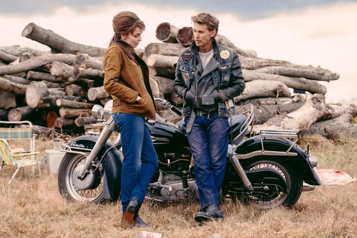 Jodie Comer stands next to Austin Butler in The Bikeriders.