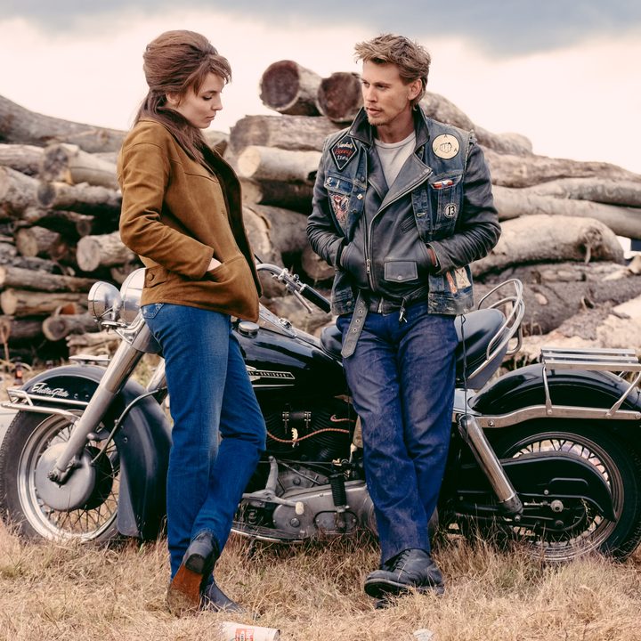 Jodie Comer stands next to Austin Butler in The Bikeriders.