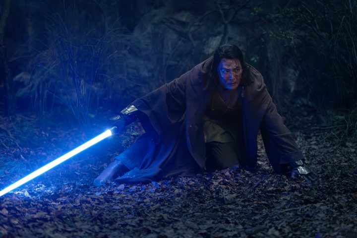 Master Sol crouches while holding his blue lightsaber in The Acolyte.