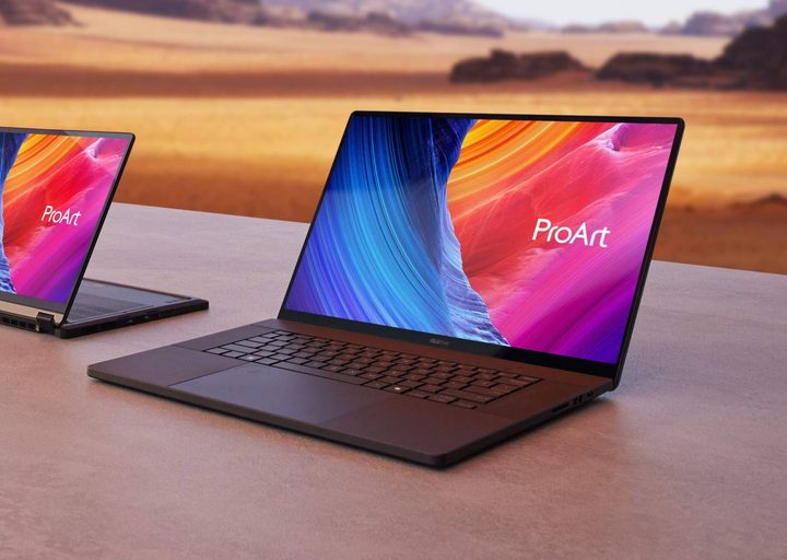 An Asus ProArt laptop on a surface against a desert background.