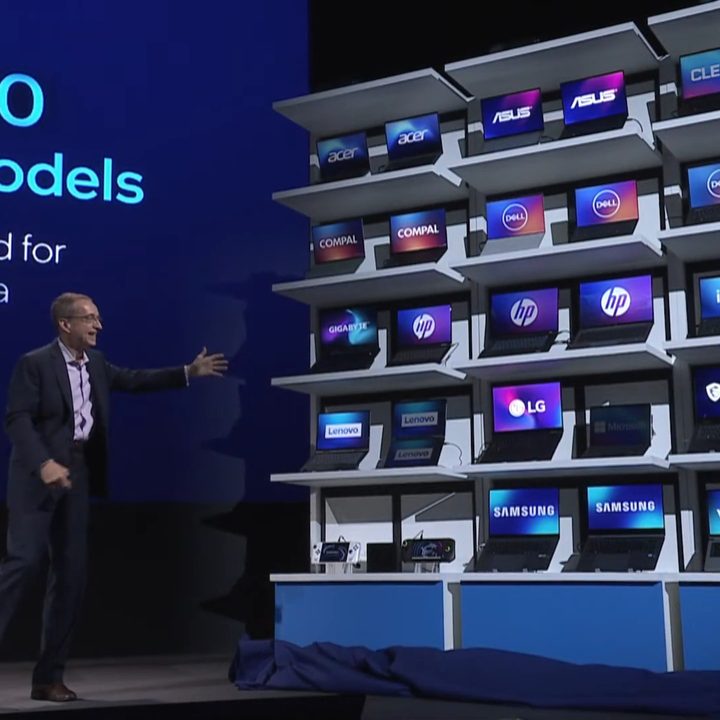 A wall of laptops at Computex 2024 with Intel CEO Pat Gelsinger standing next to them.