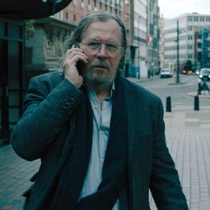 A man on a phone walks down the street.