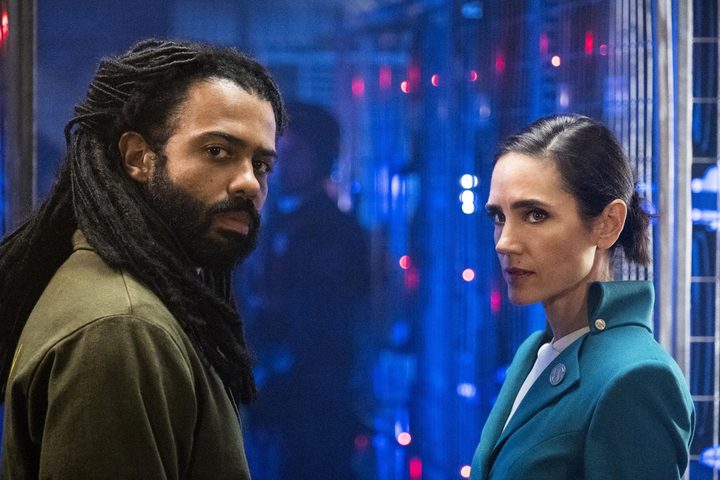 A man and woman stand next to each other and look back.
