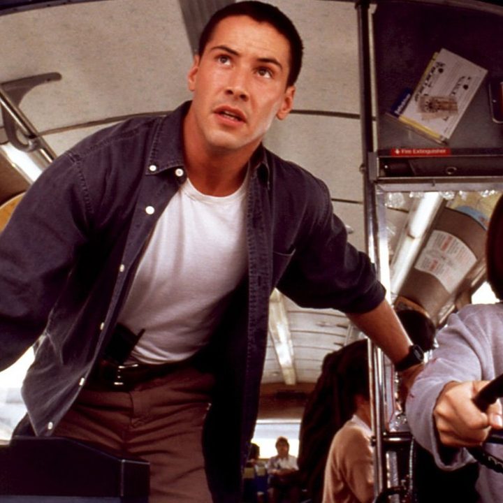 Keanu Reeves stands by Sandra Bullock as she drives a bus in a scene from the movie Speed