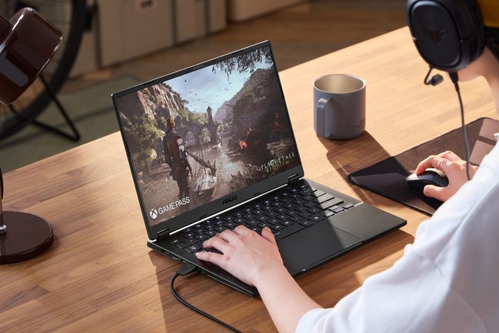 The TUF Gaming 14 laptop being played on a wooden table.