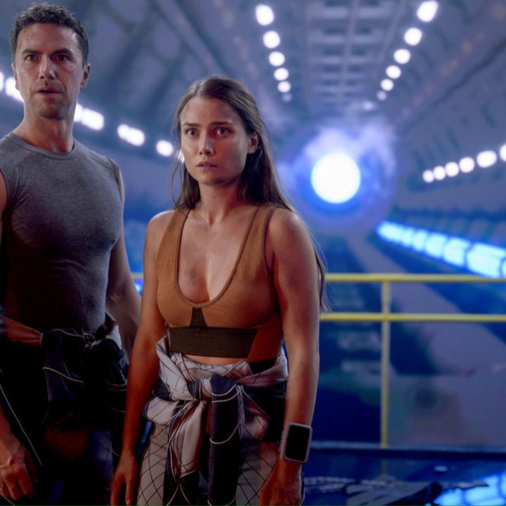A woman and a man stand next to each other and stare.