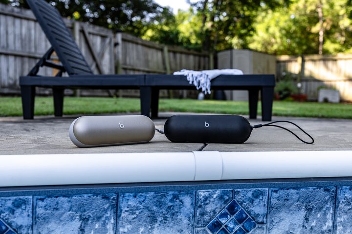 A pair of Beats Pill speakers alongside a pool