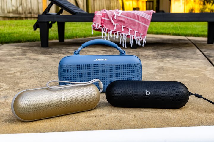 The gold and black Beats Pill speakers in front of the Bose SoundLink Max.