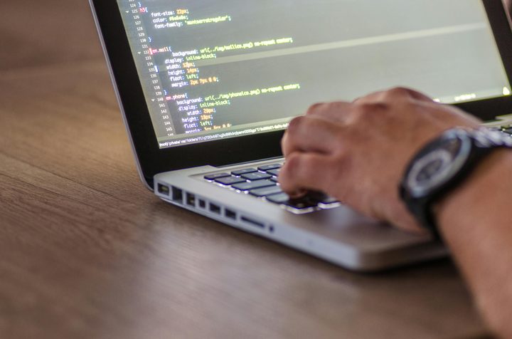 A laptop is open with code on the screen.