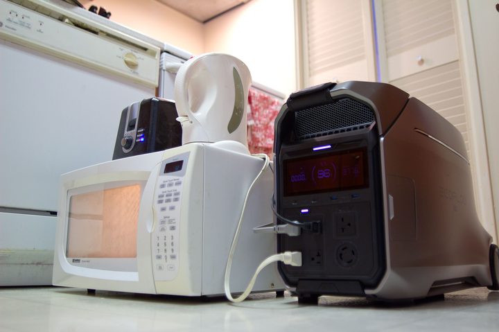 The EcoFlow Delta Pro 3 power station powering a microwave, kettle, and toaster simultaneously.