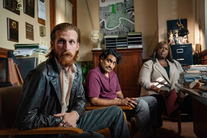 Three people look over in Hit Man.