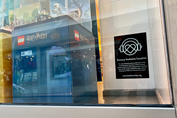 The KultureCity logo on the window of a Lego Store.