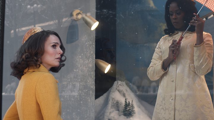 Natalie Portman standing and looking off to the side, Moses Ingram above her in a scene from Lady in the Lake.