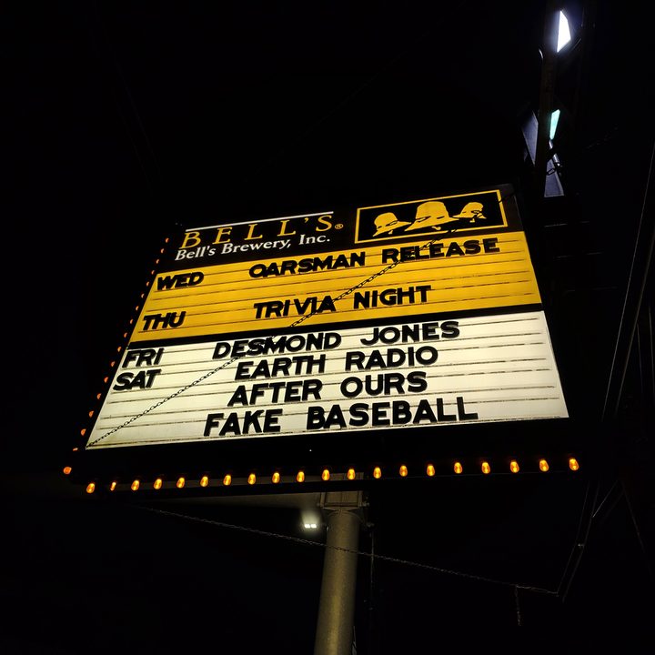 Photo of a yellow and white sign for a bar at night, taken with the Motorola Edge (2024).