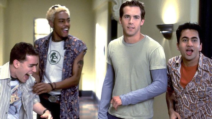 Ryan Reynolds and Kal Penn standing with two other men laughing in a scene from National Lampoon's Van Wilder.