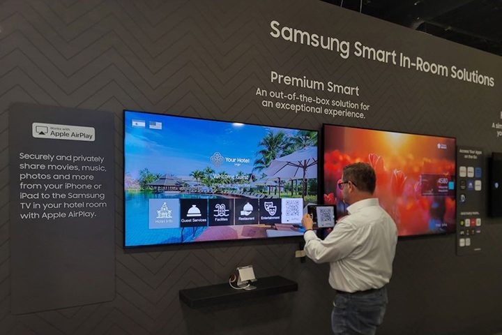 A man looking at a Samsung Hospitality TV at a trade show.
