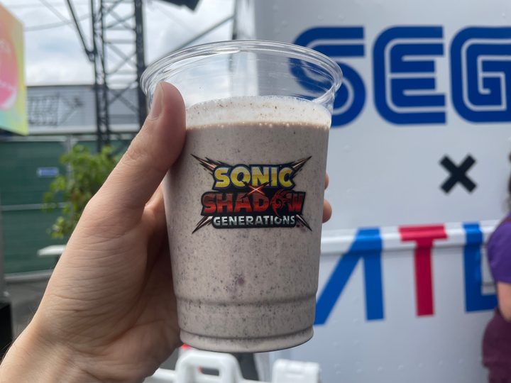 A hand holds a Shadow milkshake.
