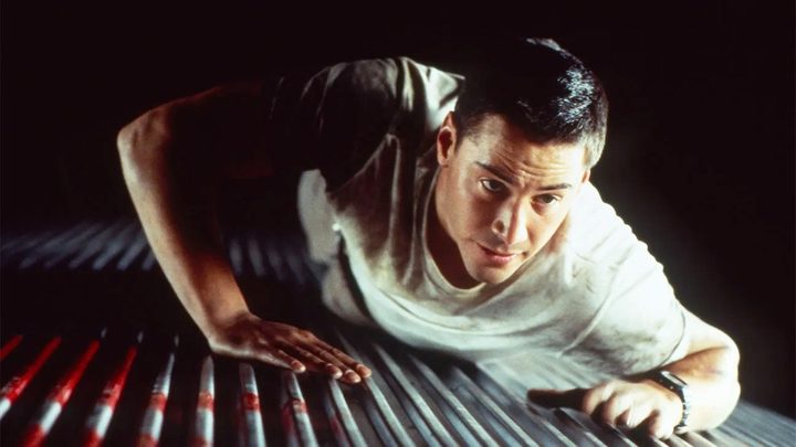A man lies on top of a subway car in Speed.