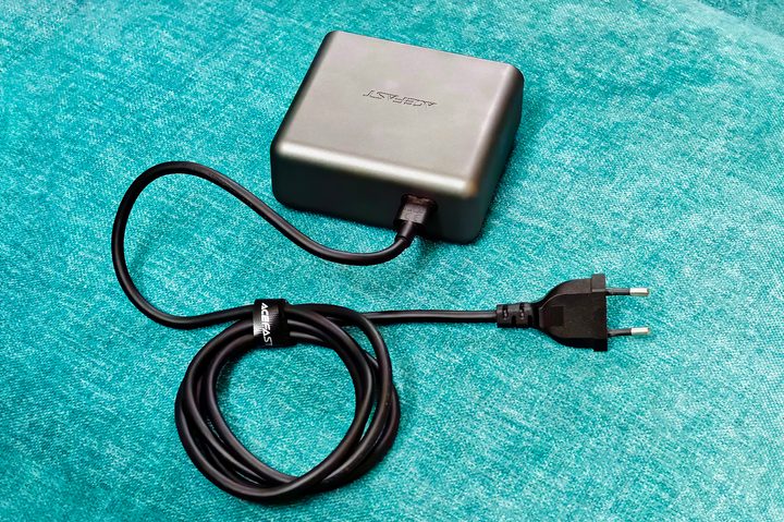 5-feet cable with the Acefast Z4 218W fast charger with display and transparent front panel kept on a blue fabric surface.