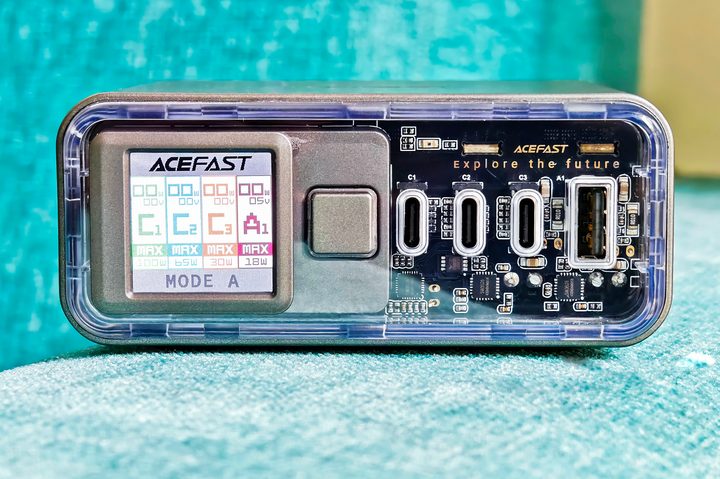Acefast Z4 218W fast charger with display and transparent front panel kept on a blue fabric surface.