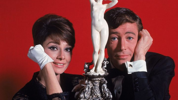 Audrey Hepburn and Peter O'Toole smiling and looking at the camera in a promo photo for How to Steal a Million,