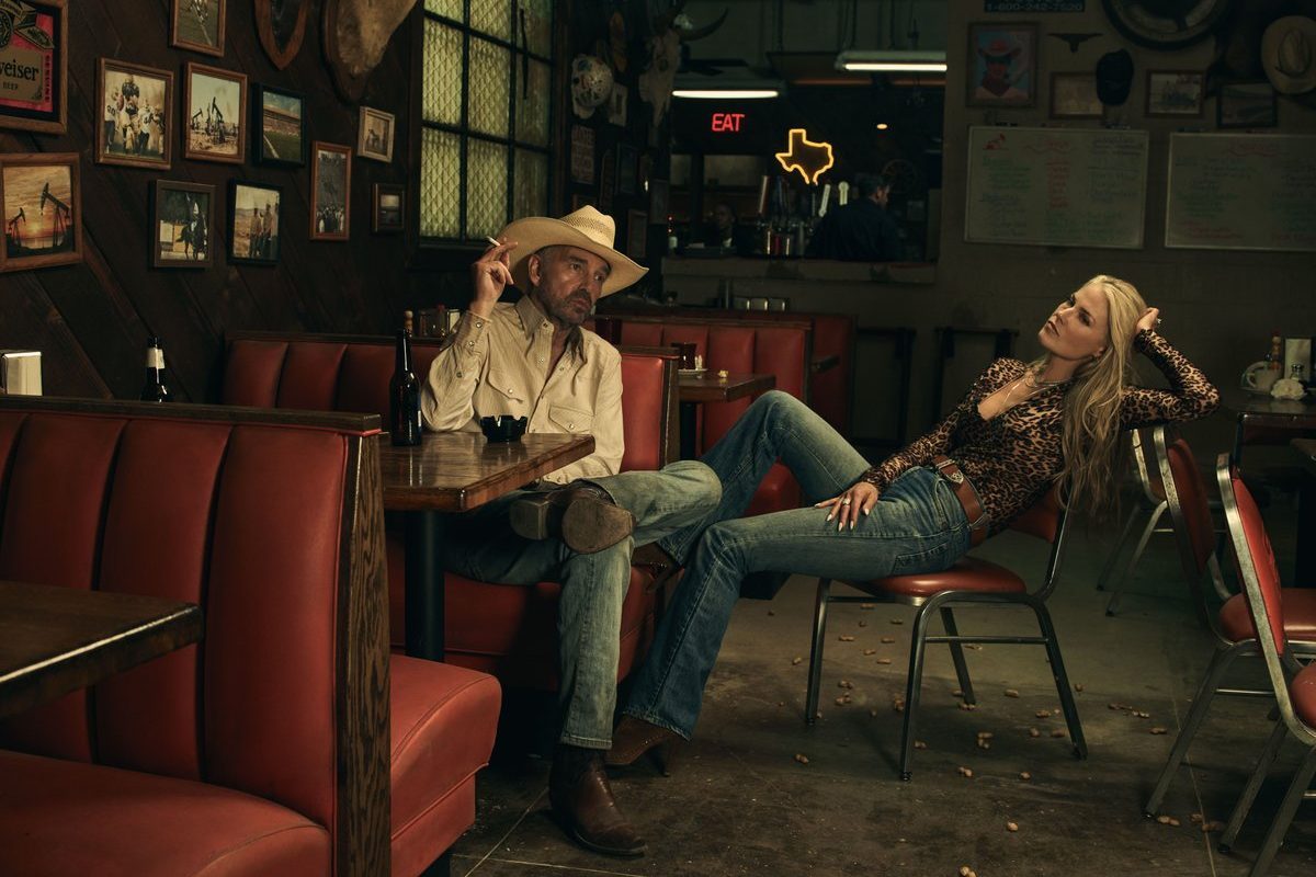 Bill Bob Thornton sits in a booth as Ali Larter sits beside him.