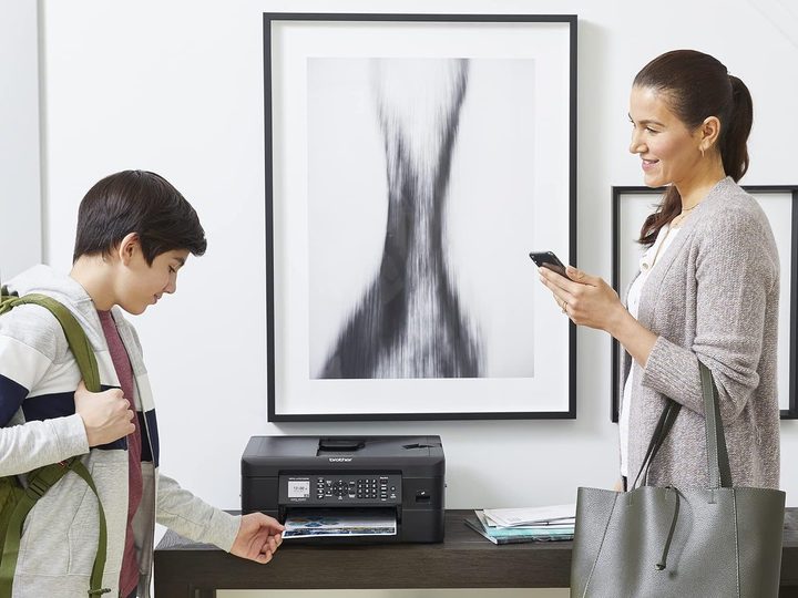 A student grabs his homework that has just been printed by a Brother MFC-J1010DW all-in-one printer.