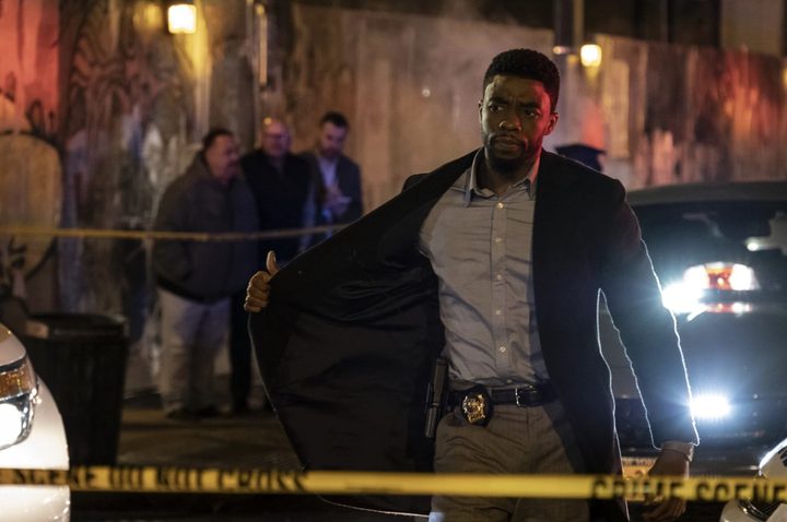 Chadwick Boseman shows his badge in 21 Bridges.