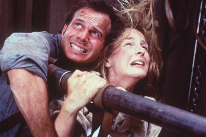 A man and woman hold a pipe while looking distressed.