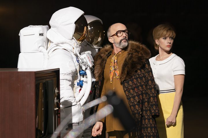 A man, a woman, and some astronauts stand in Fly Me to the Moon.
