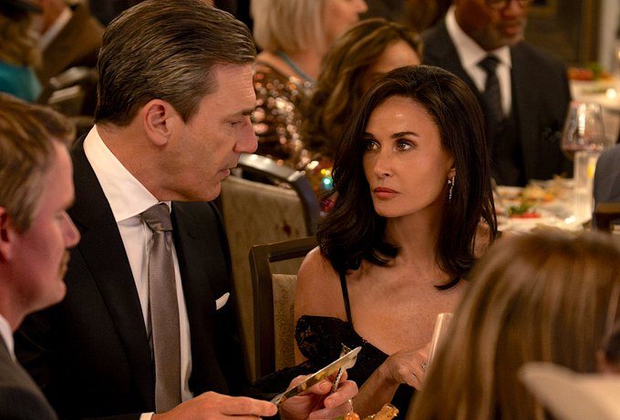 A man looks at a woman while she sits next to him.