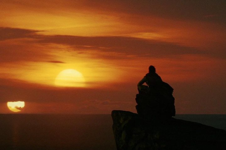 Luke watches two suns set over the ocean in Star Wars: Episode VIII - The Last Jedi.