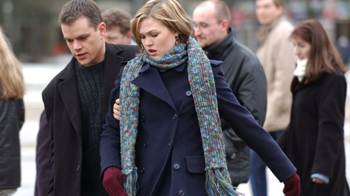 Matt Damon as Jason Bourne leading Julia Stiles as Nicky through a crowded street in The Bourne Supremacy.