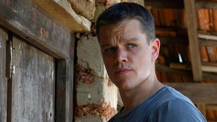 Matt Damon as Jason Bourne looking to the distance with a concerned expression in The Bourne Supremacy.