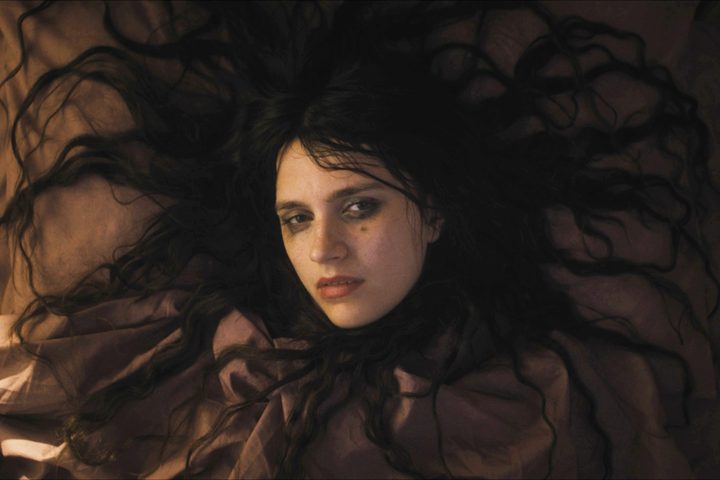 Nell Tiger Free lies with her hair sprawled out on a bed in The First Omen.
