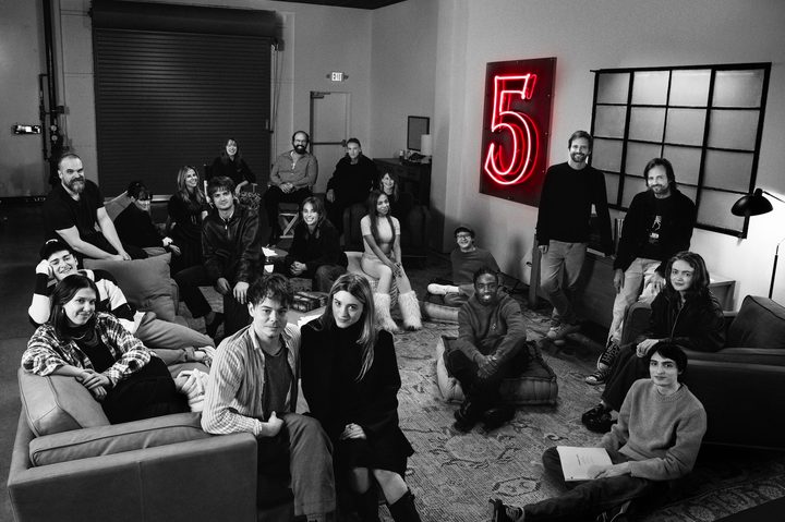 A group of people gather in a room and pose for a photo.