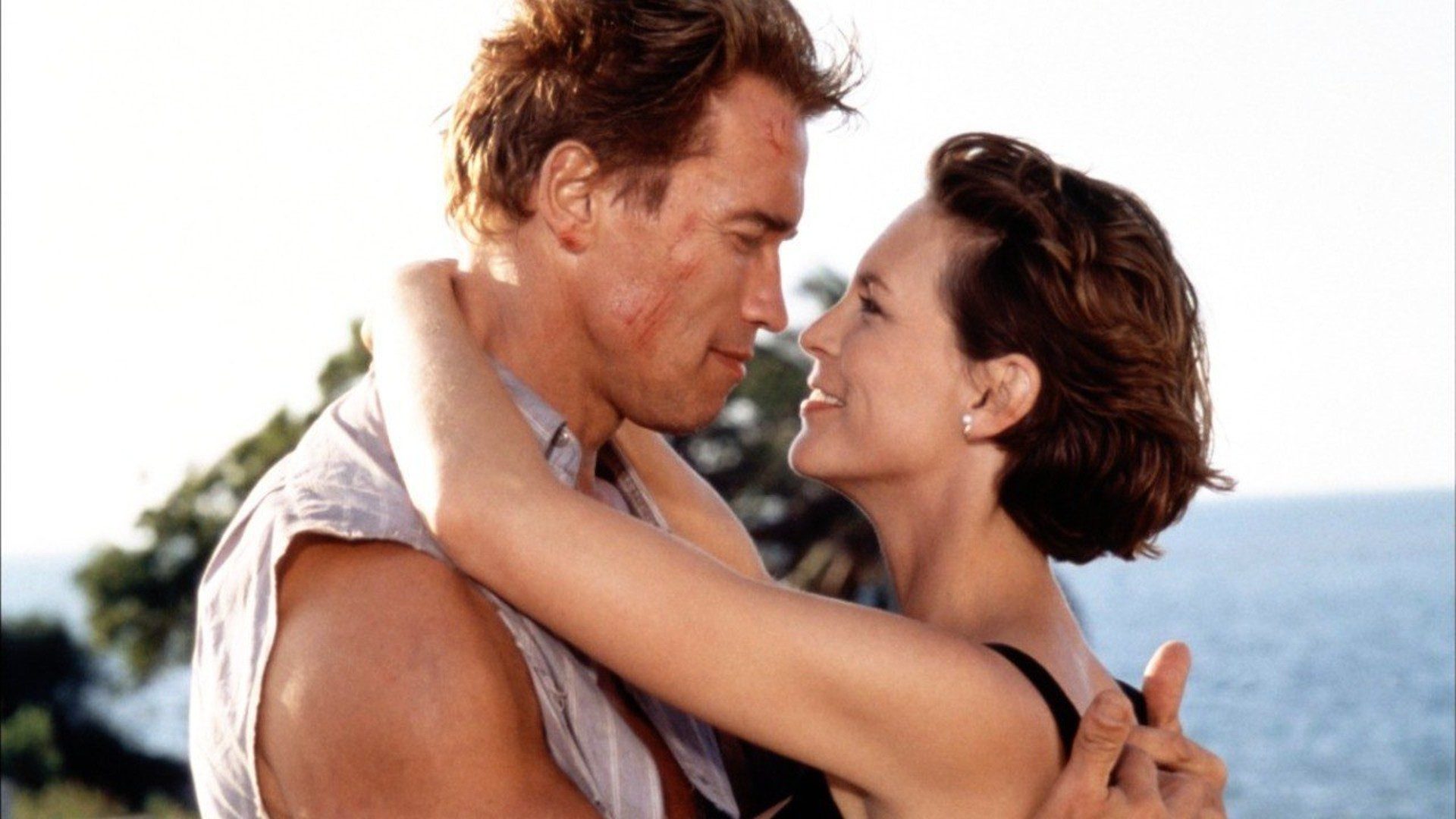 Arnold Schwarzenegger and Jamie Lee Curtis embrace in a still from the movie True Lies