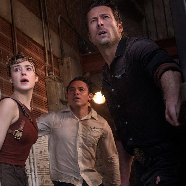 Daisy Edgar-Jones, Anthony Ramos, and Glen Powell stare offscreen at a tornado, probably, in a still from the movie Twisters.