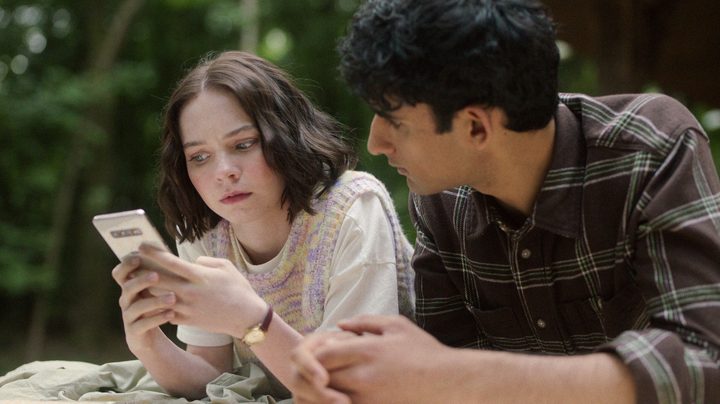 A girl checkers her phone in A Good Girl's Guide to Murder.
