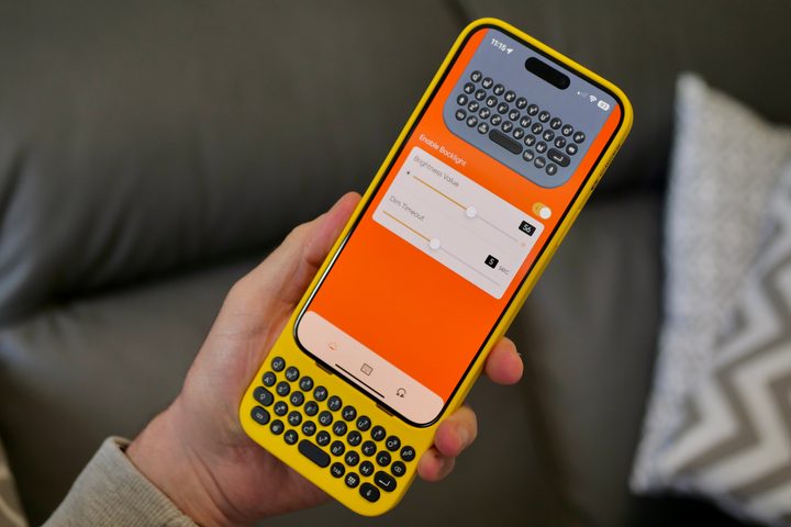 A person holding the iPhone 15 Pro Max inside the Clicks Keyboard case, showing the app.