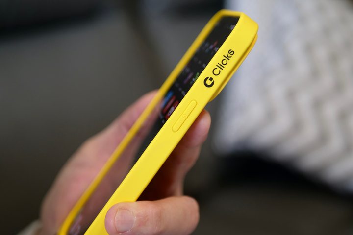 A person holding the iPhone 15 Pro Max inside the Clicks Keyboard case, showing the side.
