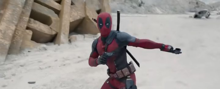 Deadpool brandishes his pistols in front of a wrecked 20th Century Fox sign in Deadpool & Wolverine