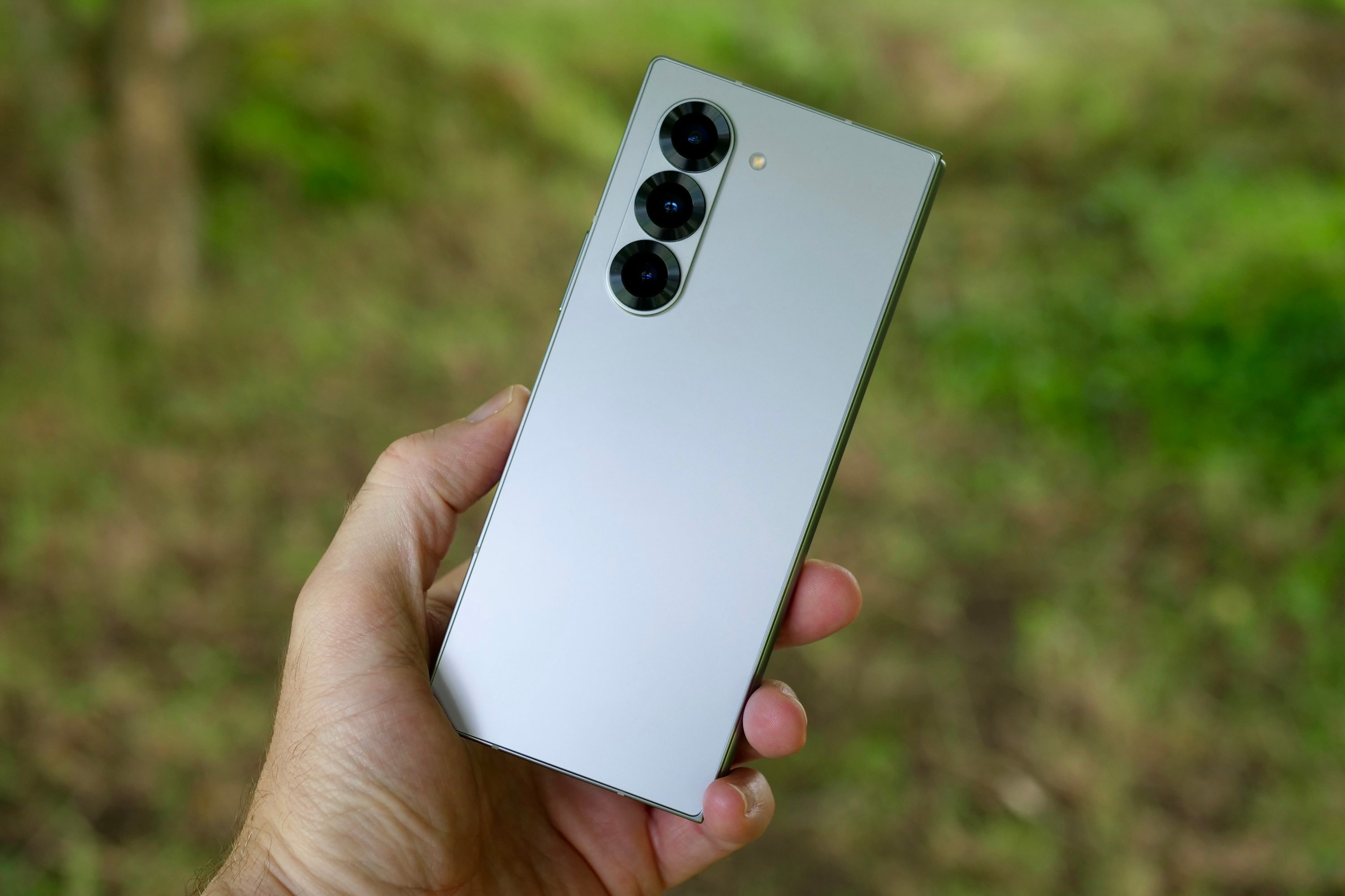 A person holding the Samsung Galaxy Z Fold 6, showing the back of the phone.