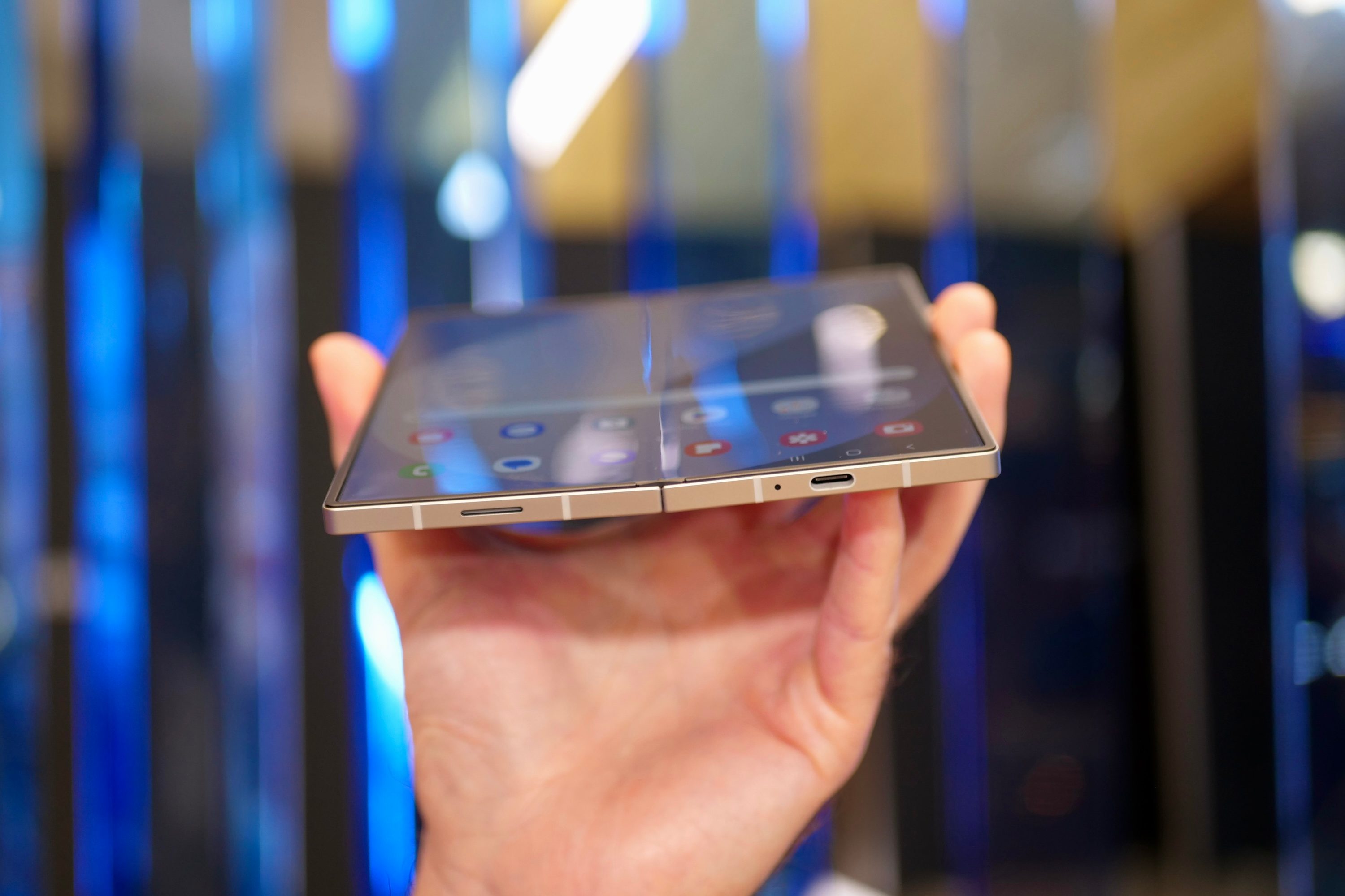 A person holding the open Samsung Galaxy Z Fold6, showing the bottom of the device.