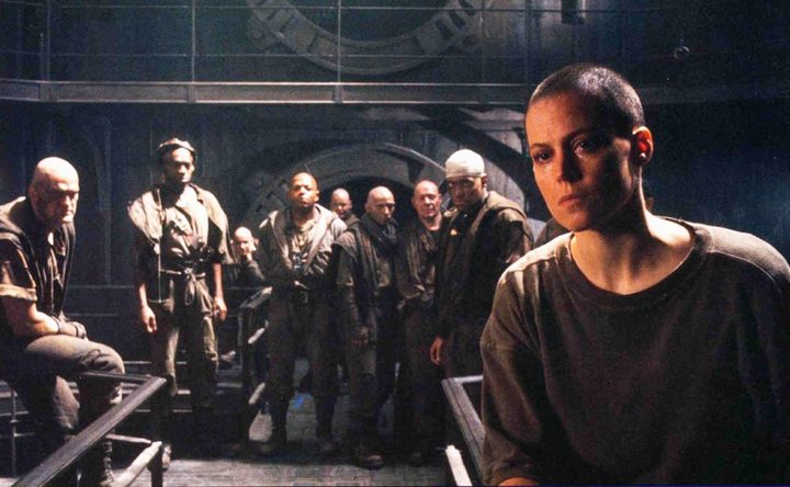Ripley and a group of men stand in Alien 3.