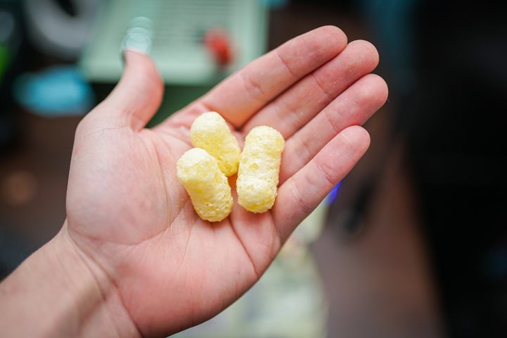 Kuai Kuai corn puffs sitting in someone's hand.