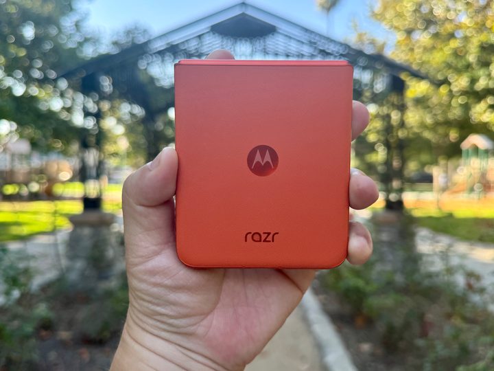 Motorola Razr 2024 in Spritz Orange in hand showing leather back.