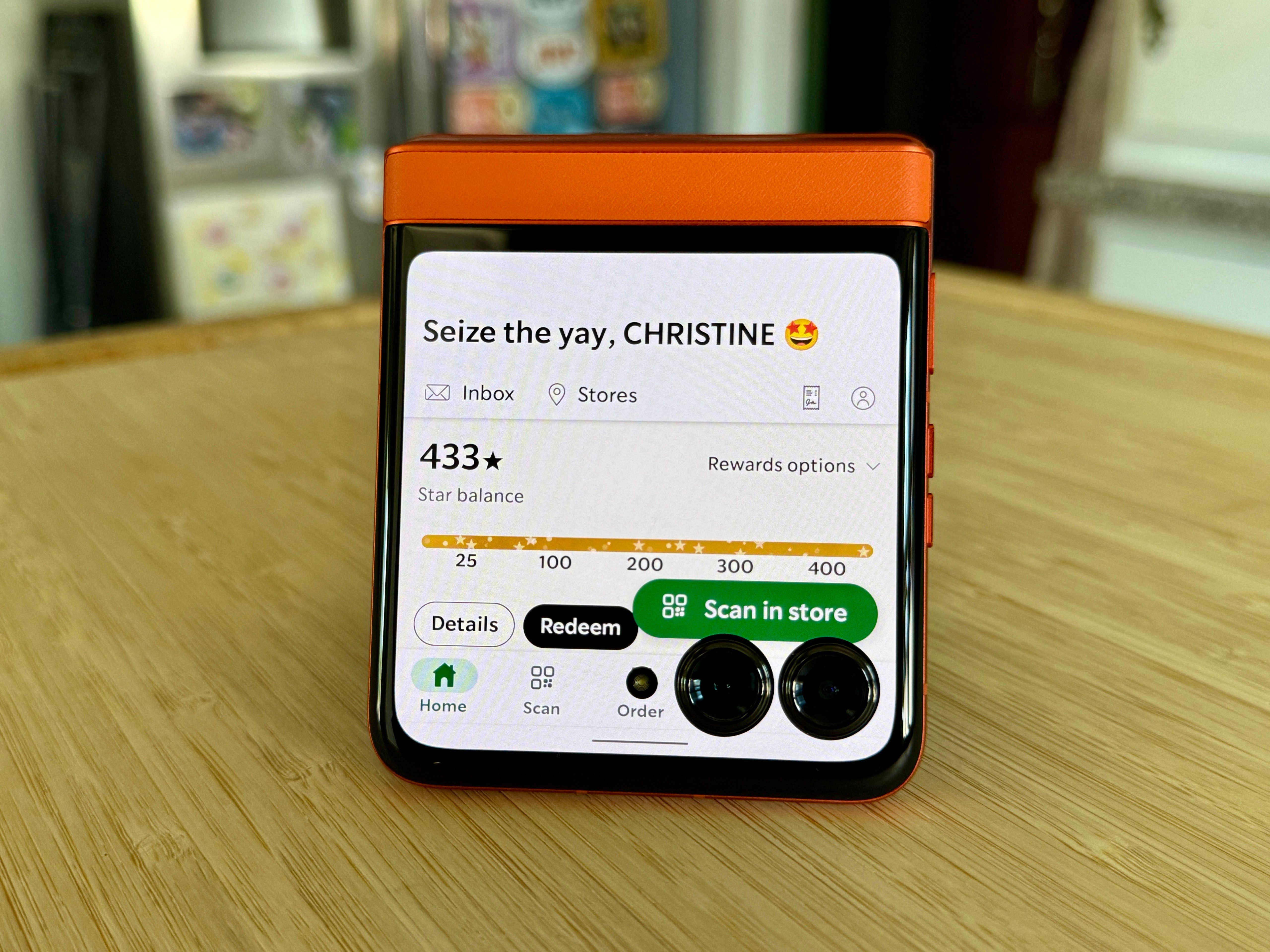 Motorola Razr 2024 in Spritz Orange showing the Starbucks app on the cover display.
